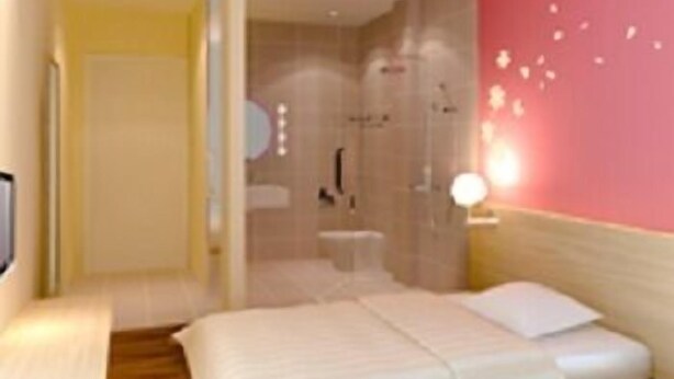 Una habitación de hotel con cama, baño y zona de ducha.