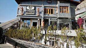 A building with a sign for 'PYRAMID CAFE | LOUNGE | BAR | MICROBREWERY'. - Bridge View Regency (Shimla)