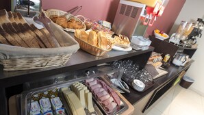 A buffet with various food items including bread, pastries, and cheese. - Source Hotel (Paris)