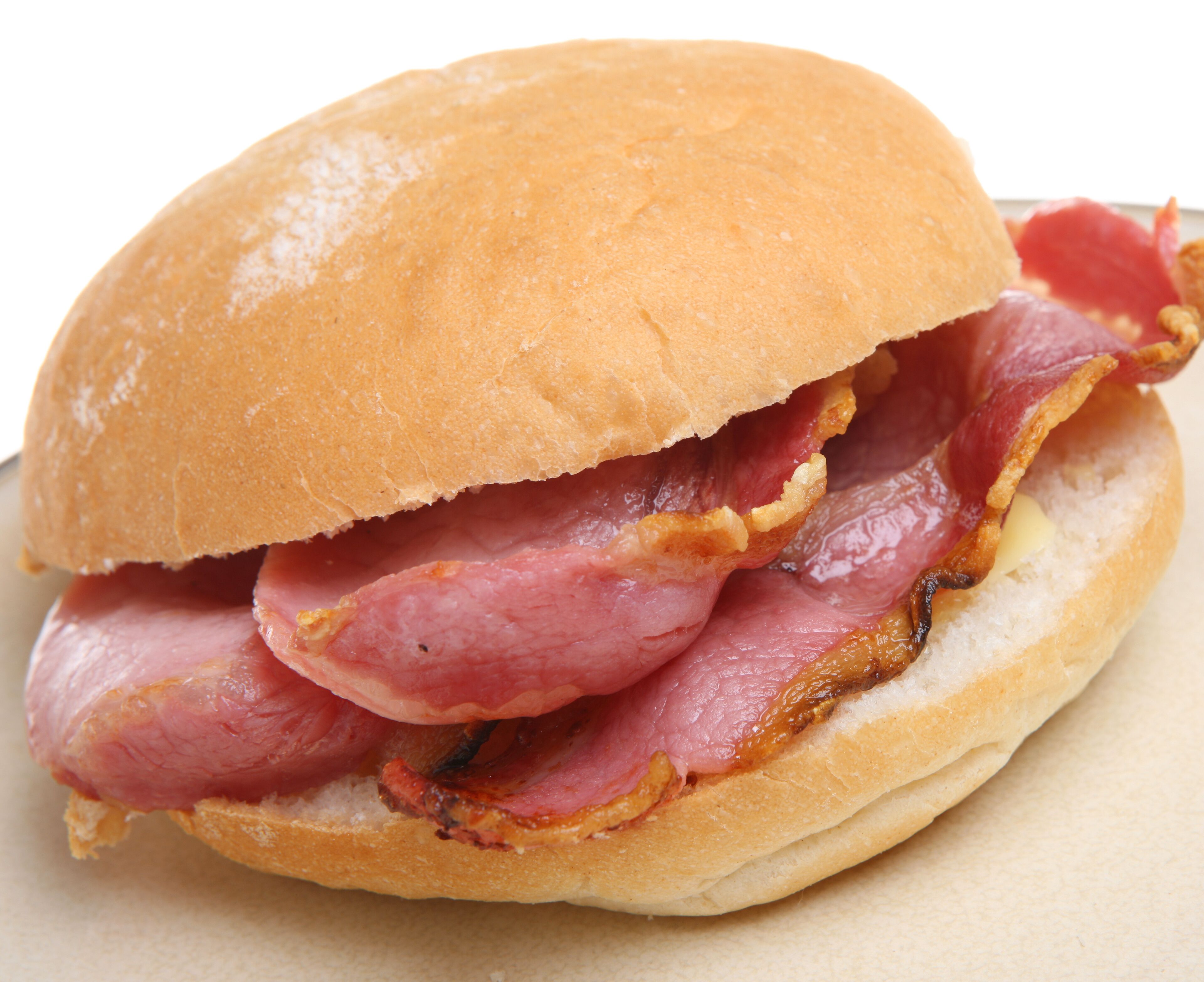 A sandwich with a bun, bacon, and ham.