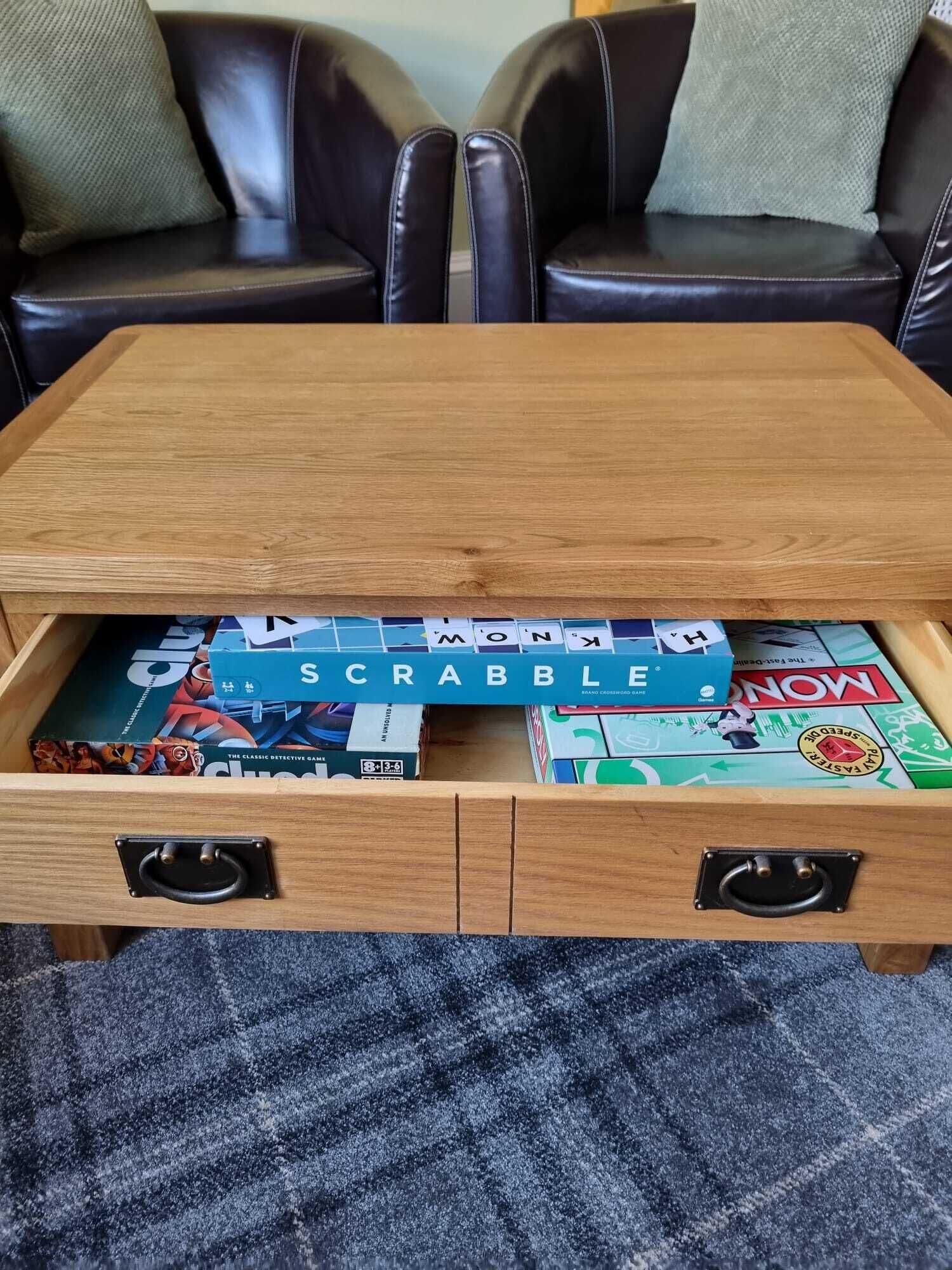 A wooden chest of drawers with a Scrabble game on top.