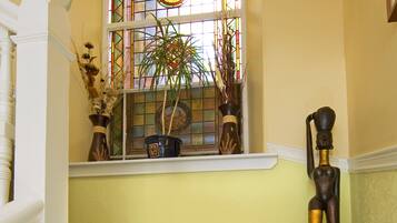 A staircase with plaid carpeted steps, a stained glass window, and a statue.