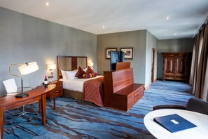 A hotel room with a bed, desk, chair, and a small table. - Lawlors of Naas (Naas)