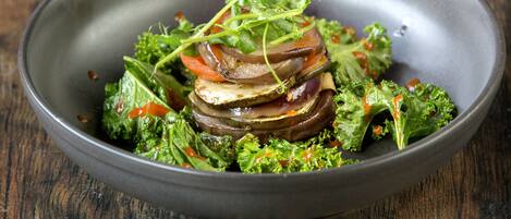 A bowl of salad with various vegetables and greens.