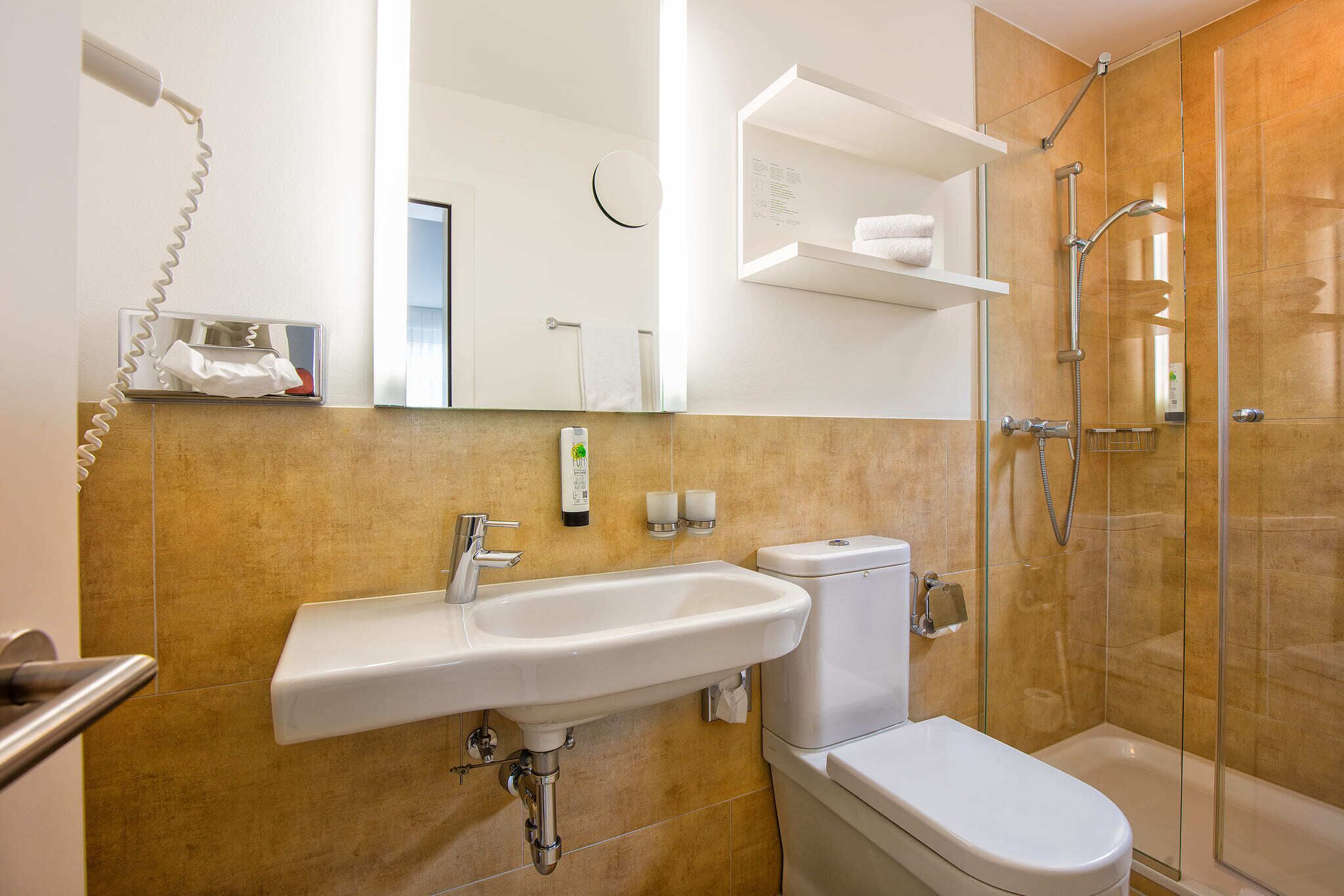Een badkamer met een wastafel, toilet en douche.