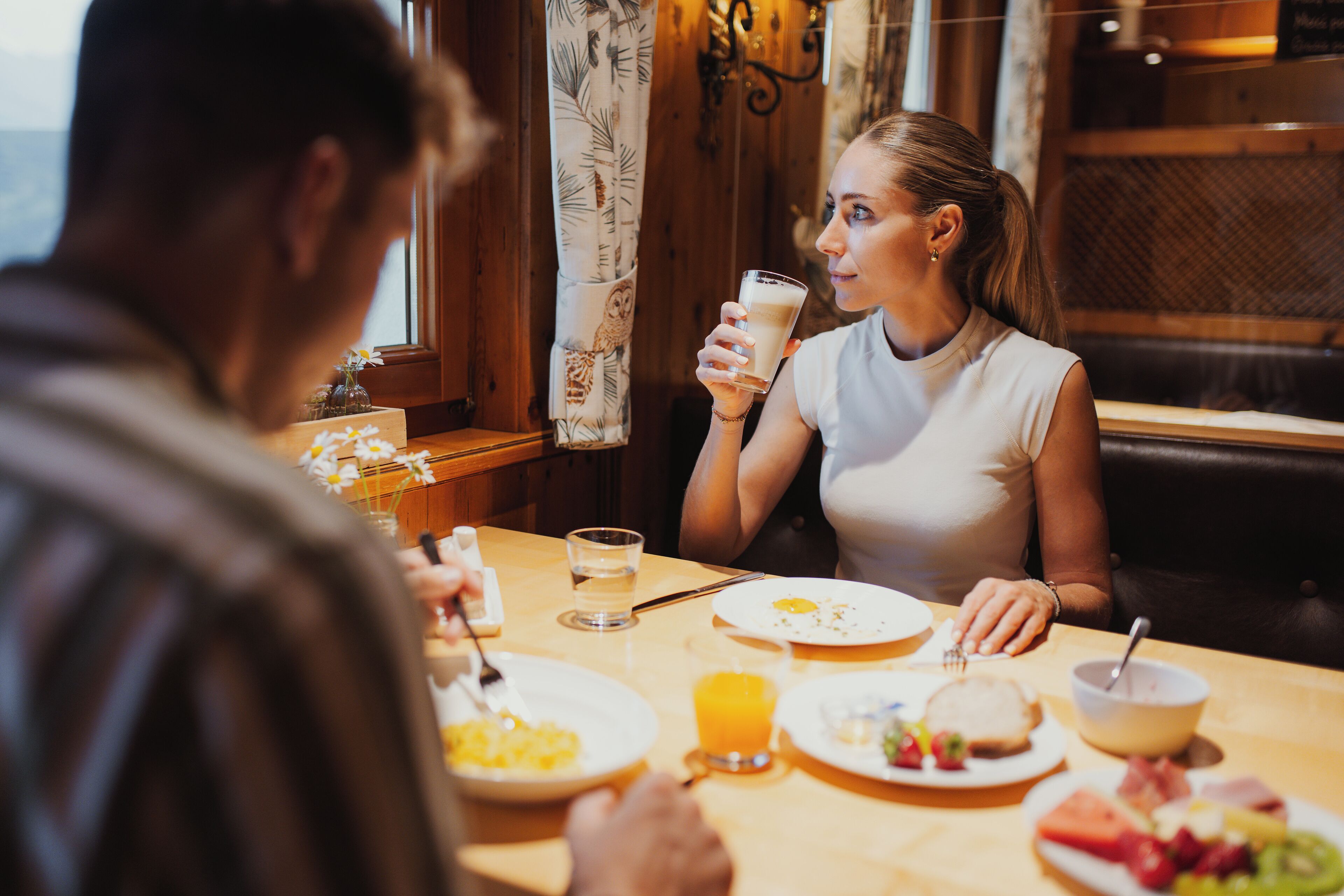A dining table with breakfast items including eggs, toast, and fruit.