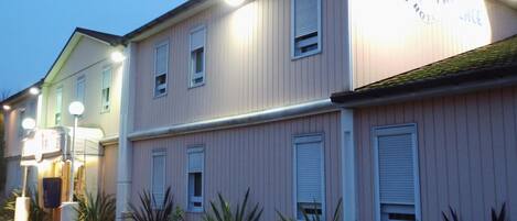 A pink building with a sign that reads "Quick Hotel."