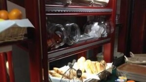 Un buffet proposant une variété d’aliments, notamment du pain, des pâtisseries et des fruits.