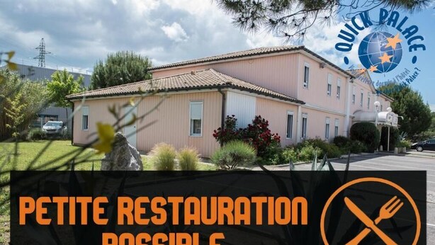 Un bâtiment à deux étages, doté d’une façade rose et d’un toit en tuiles, sur lequel est apposée une pancarte indiquant « PETITE RESTAURATION POSSIBLE » ainsi qu’un pictogramme interdisant la vente de nourriture.