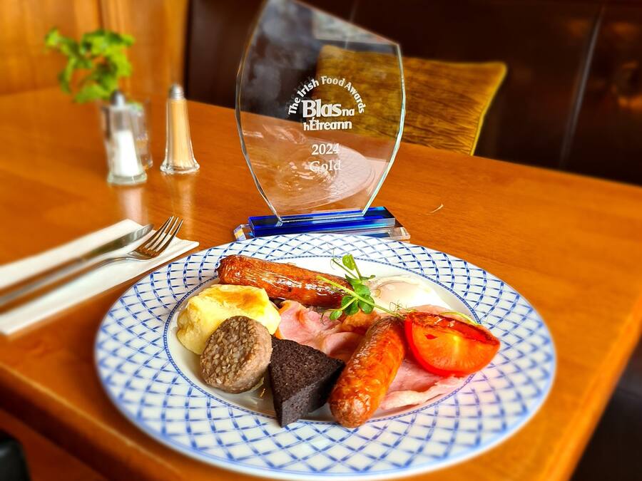 A plate of food on a table with a glass award for The Irish Food Awards 2024 Gold.