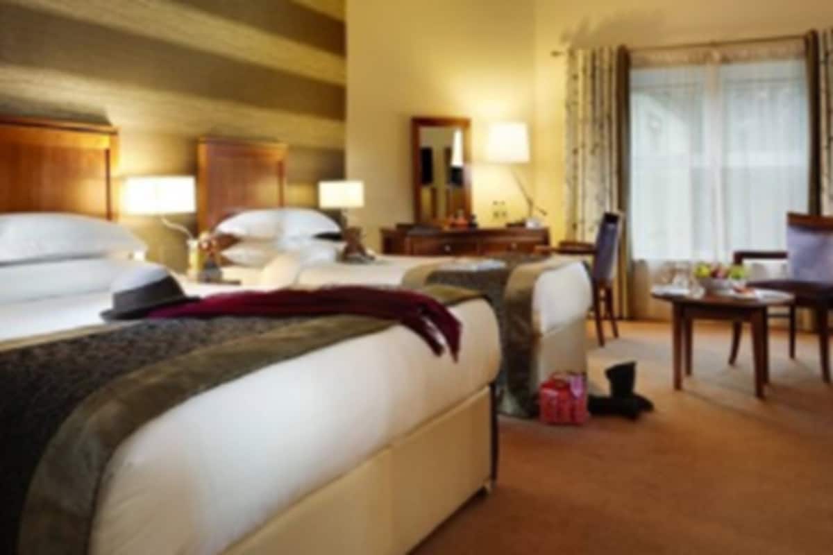 Une chambre d’hôtel avec un grand lit, un bureau et une chaise.