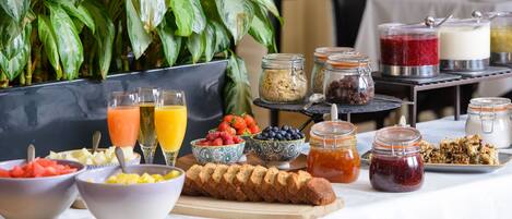 A breakfast buffet with various fruits, cereals, and spreads.