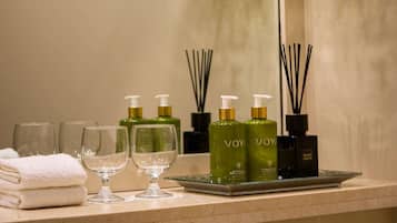 A bathroom vanity with toiletries, a towel, and two glasses.