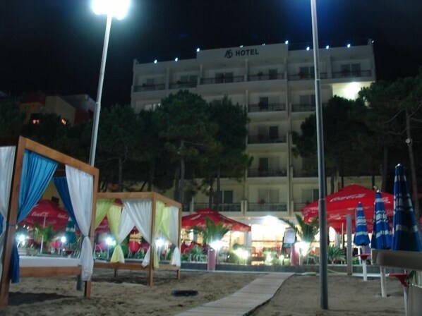 A hotel with a modern design, featuring multiple balconies and a well-lit facade.