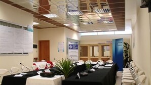 A conference room with a long table, chairs, and a whiteboard. - AS Hotel (Golem)