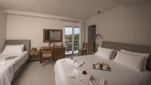 Een hotelkamer met twee bedden, een bureau, een stoel en een balkon met uitzicht.