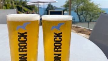 Zwei Biergläser mit 'Devon Rock'-Branding auf einem Tisch im Freien.