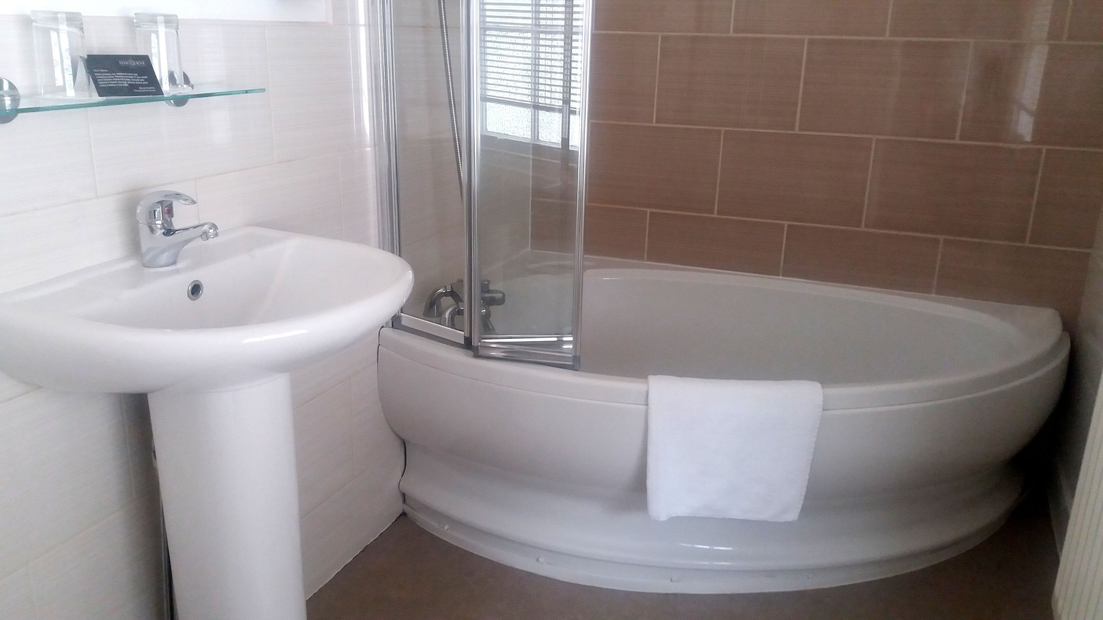 A bathroom with a white sink, a glass shower enclosure, and a bathtub.
