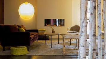 A modern living room with a sofa, a round table, and a chair.