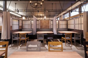 A restaurant interior with booth seating, wooden tables, and hanging pendant lights. - Hotel Vista Sapporo Odori (Sapporo)