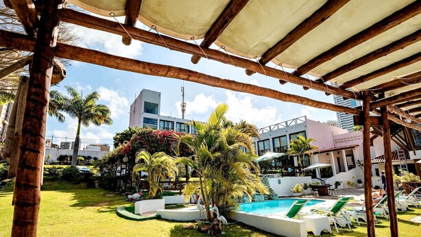 A pool area with lounge chairs and a covered seating area. - Moriah Natal Beach Hotel (Natal)