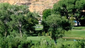 Un campo de golf con árboles y un cielo despejado.