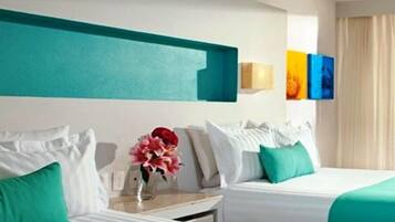 Una habitación de hotel con dos camas, ropa de cama color aguamarina, almohadas blancas, una mesita de noche con un jarrón de flores y una pared con detalles en aguamarina y obras de arte coloridas.
