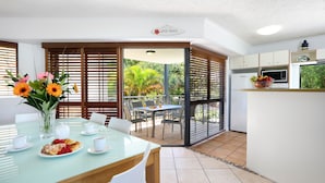 Una cocina moderna con comedor y vistas al jardín, y un cartel que dice "Surfing Paradise".