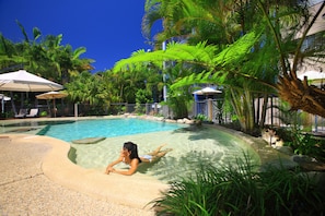 Een buitenzwembad, parasols voor strand/zwembad