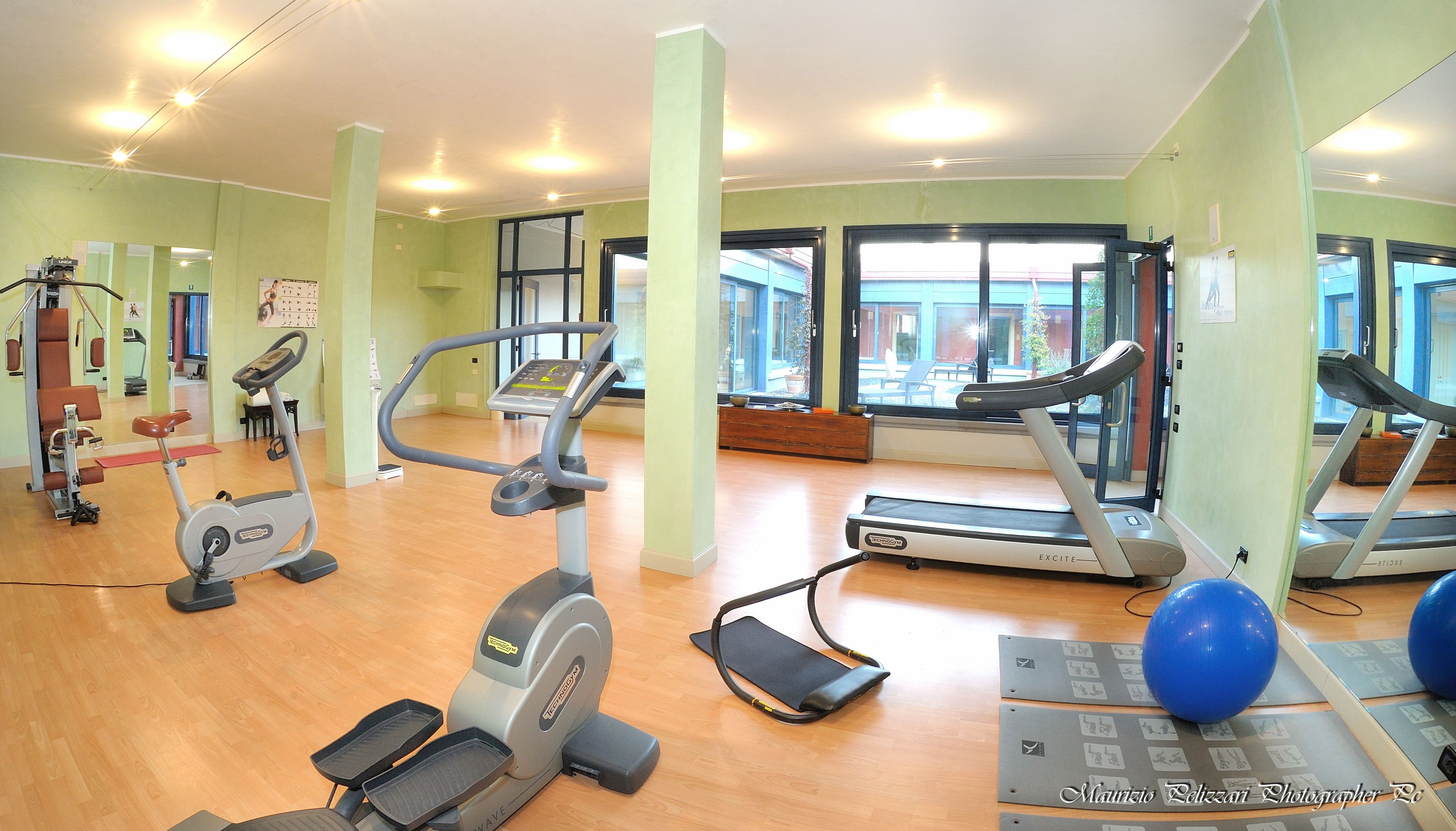 A gym with treadmills, elliptical machines, and exercise balls.
