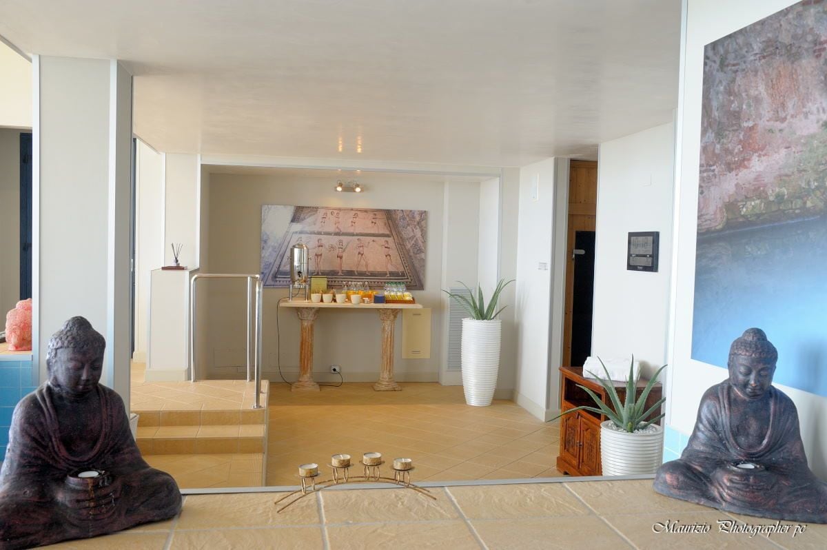 Ein Meditationsraum mit zwei Statuen, einem kleinen Altar und einem großen Gemälde.