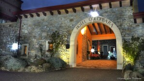 Un bâtiment en pierre doté d’une entrée en arc surmontée de l’inscription « HÔTEL COLOMBA ».