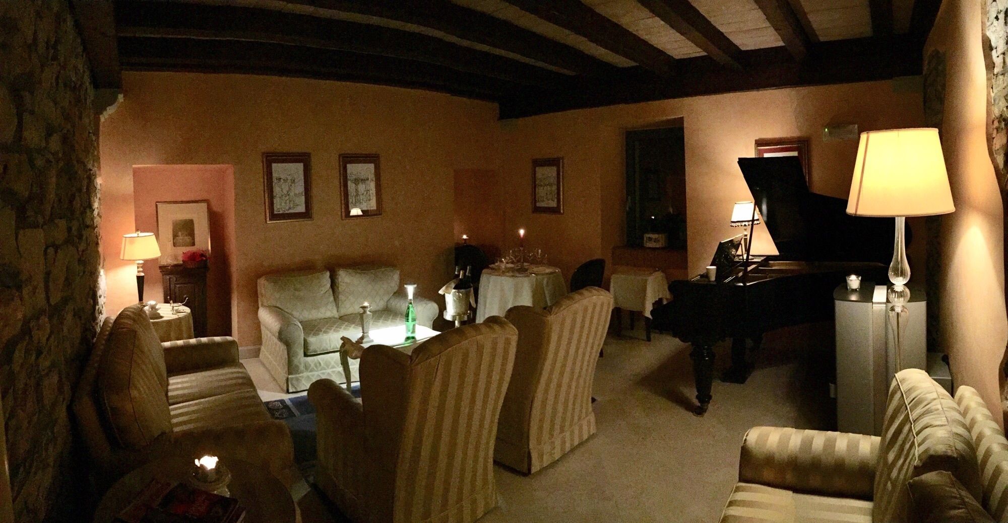 Un salon chaleureux avec un piano, des canapés et une table à manger.
