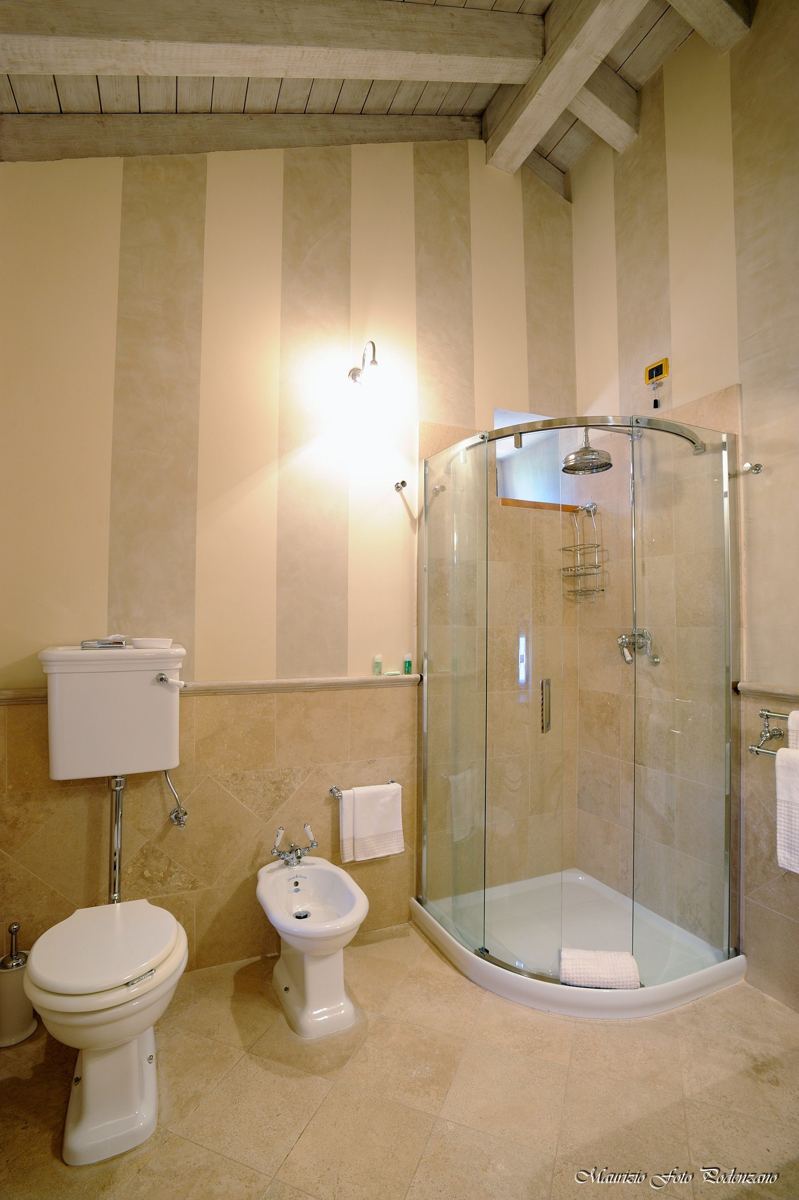 Une salle de bain avec une douche à parois de verre, des toilettes et un bidet.