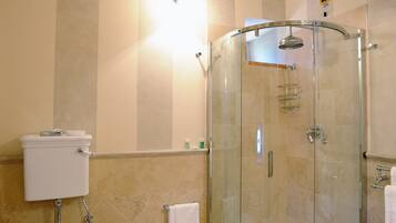 Une salle de bain avec une douche à parois de verre, des toilettes et un bidet.