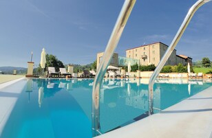 Una piscina techada, una piscina al aire libre de temporada, sombrillas