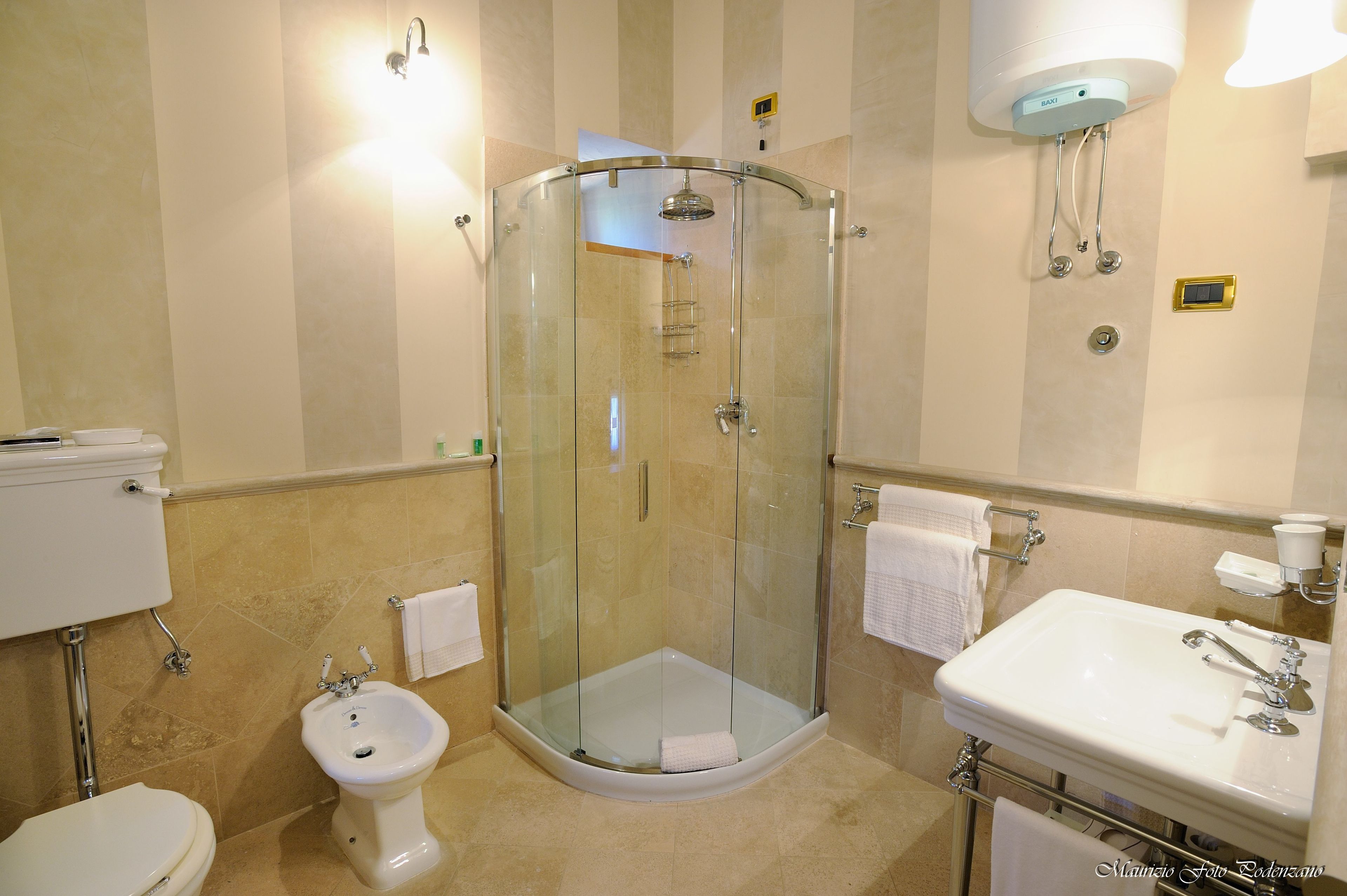 A modern bathroom with a glass-enclosed shower, a bidet, a sink, and a toilet.