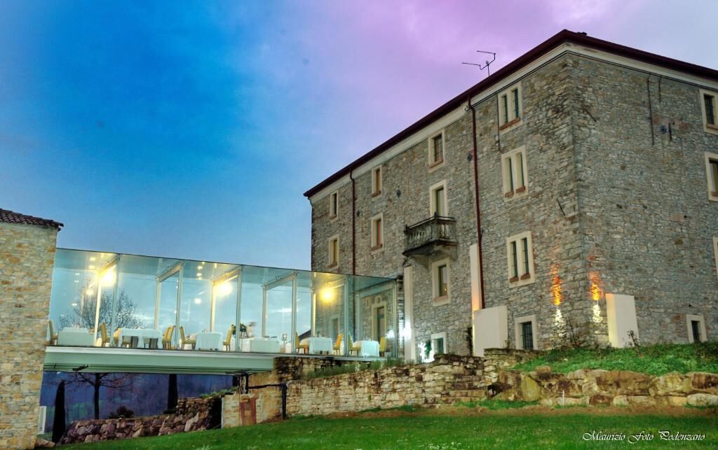A modern glass extension attached to a historic stone building.