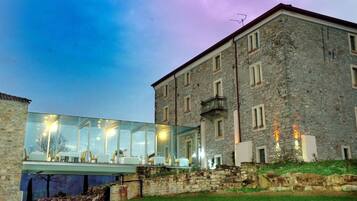 A modern glass extension attached to a historic stone building.