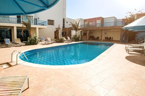 Outdoor pool, open 9 AM to 5 PM, pool umbrellas, pool loungers