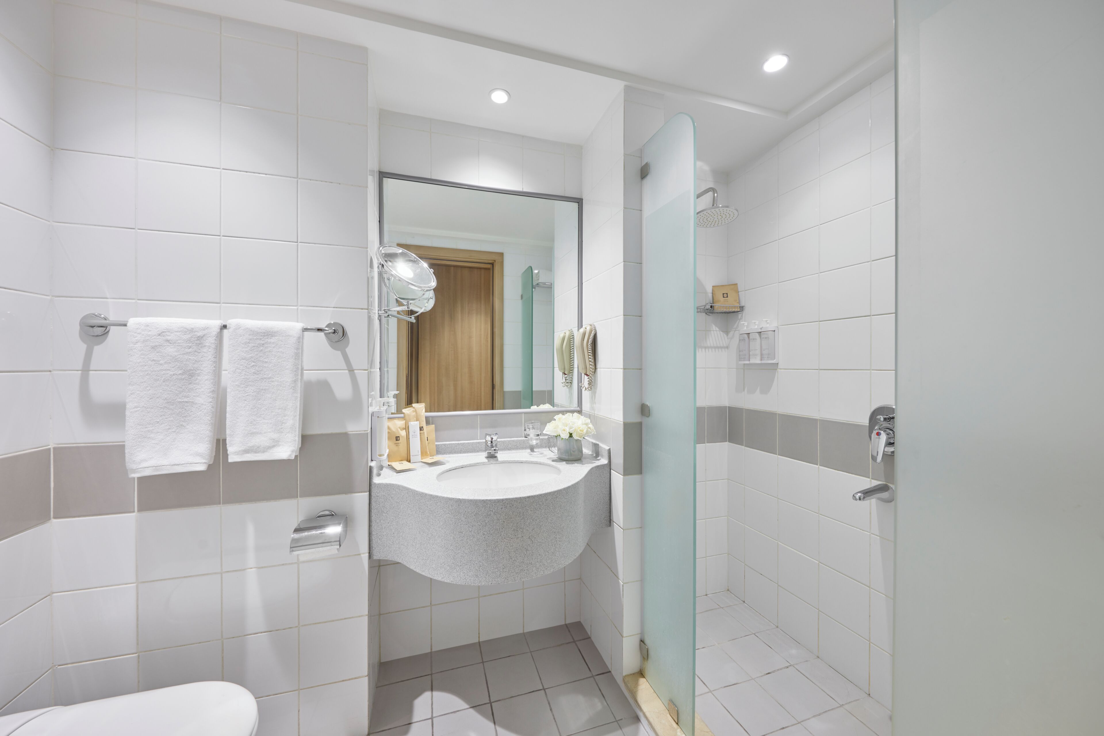 A modern bathroom with a sink, mirror, and shower.