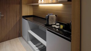 A modern kitchen with wooden cabinetry, a black countertop, and recessed lighting.
