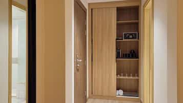 A hallway with a wooden wardrobe, a microwave, and a small shelf with glasses.