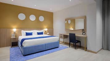 Een moderne hotelkamer met een groot bed, een bureau en een spiegel.