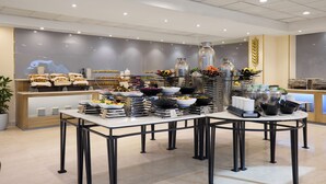 A buffet setup with various food items and serving ware.
