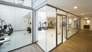A modern gym with glass walls, exercise equipment, and a wooden floor. - Globales Playa Estepona (Estepona)