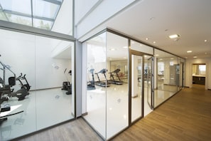 A modern gym with glass walls, exercise equipment, and a wooden floor. - Globales Playa Estepona (Estepona)