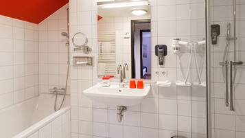 A modern bathroom with a white sink, mirror, and shower.
