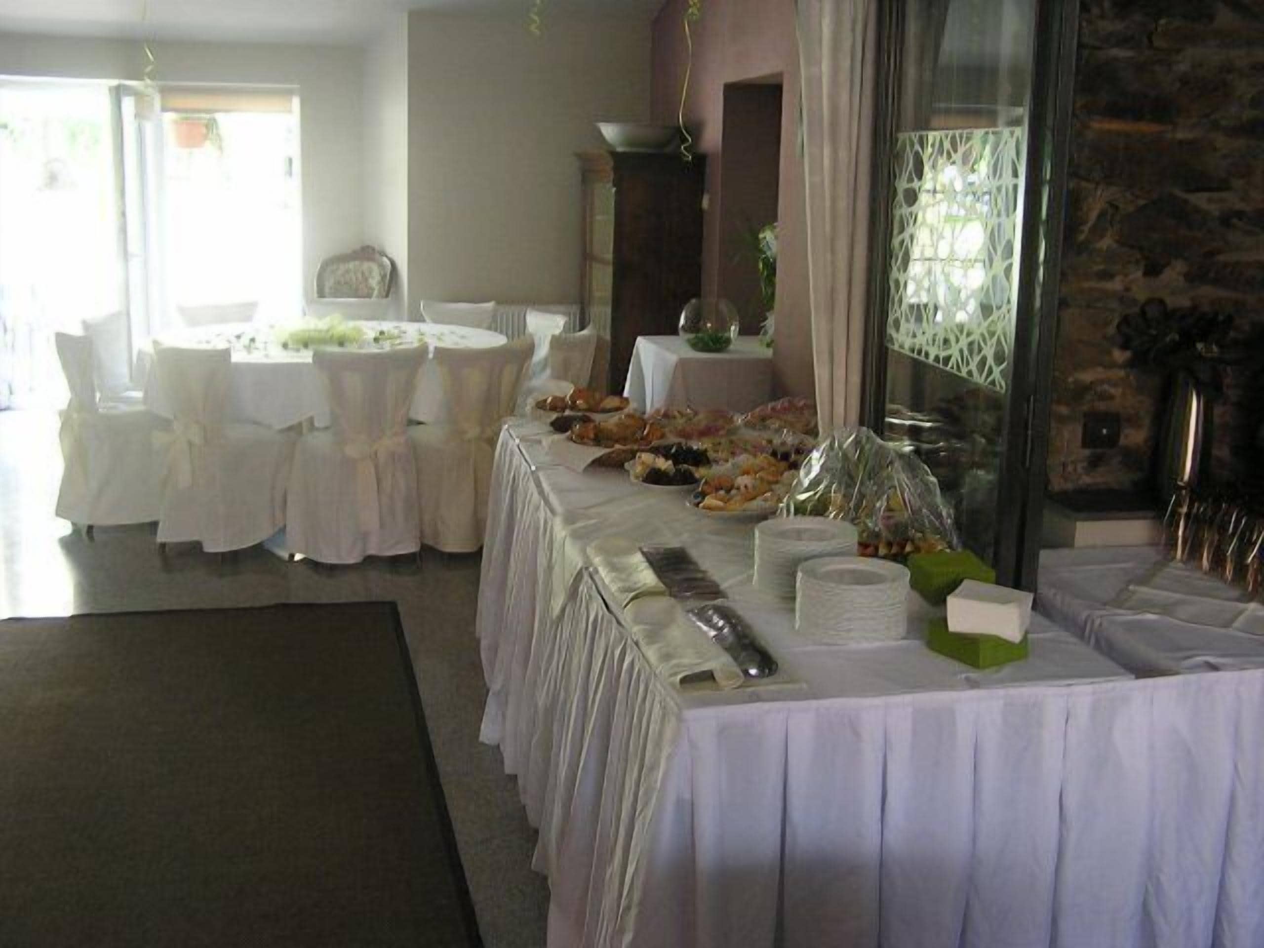 Un comedor con mesas redondas cubiertas con manteles blancos, rodeado de sillas.