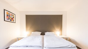 A double bed with white linens, a wooden headboard, and bedside lamps. - Alt Pension (Prague)